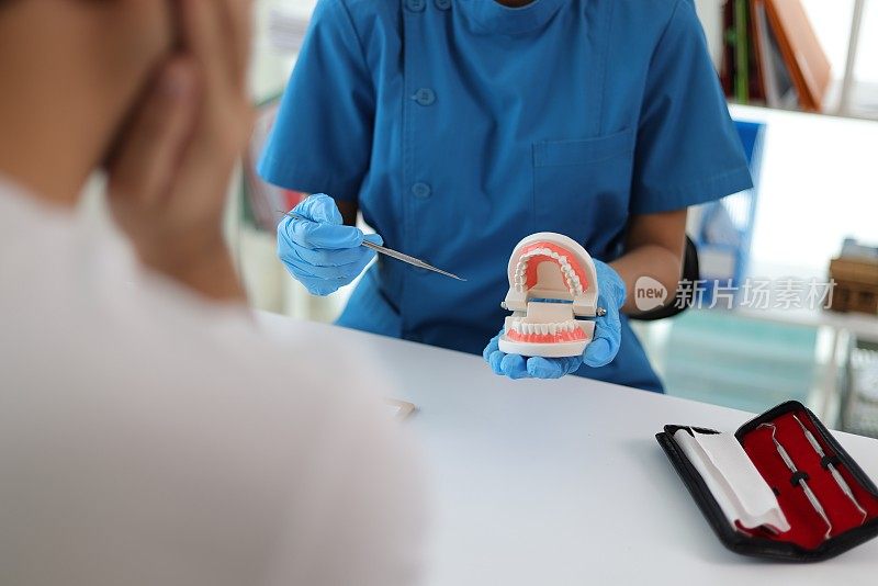 牙科医生提供的口腔、牙龈和牙齿保健咨询服务。男性牙痛患者在医院与医生讨论。
