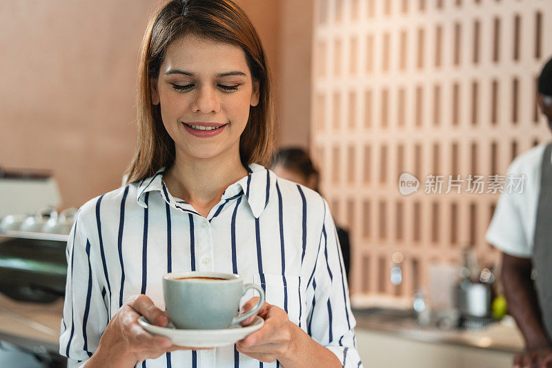 一位热爱咖啡的年轻女子在一家黑人咖啡馆里享受着咖啡的香味和味道。