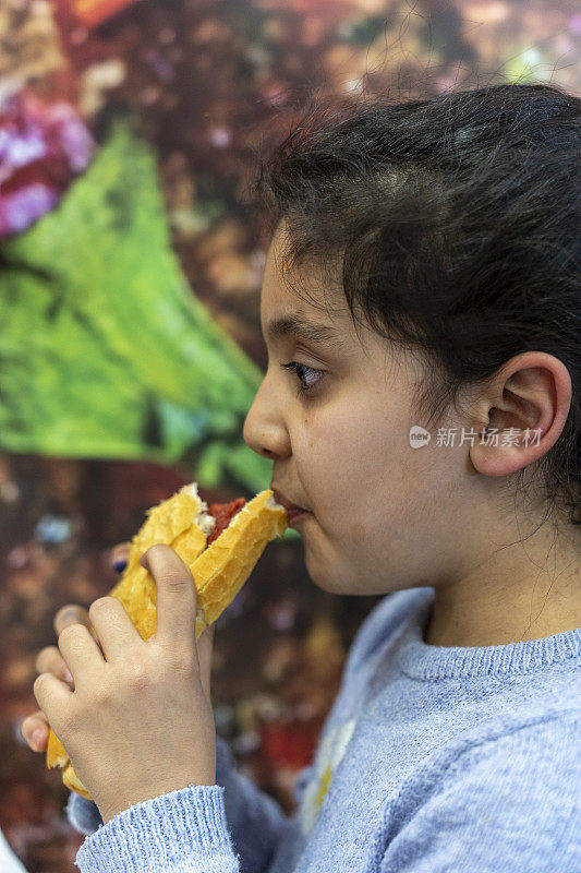 一个女孩在吃三明治。