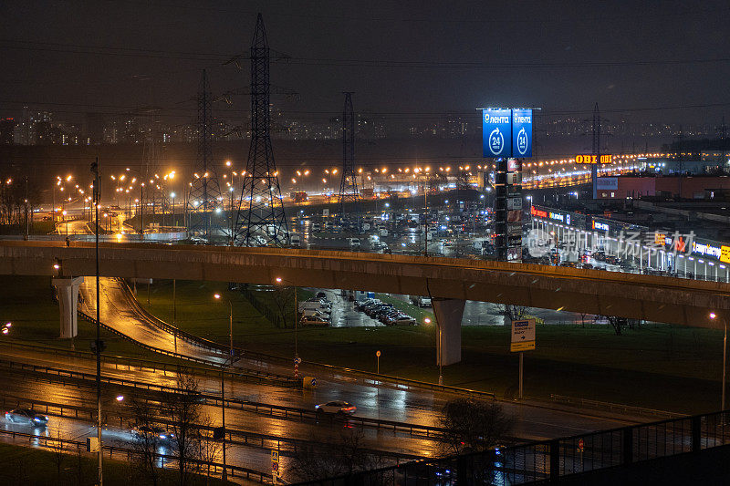在夜间的道路上，汽车驶过一座桥和一个路口。城市城市