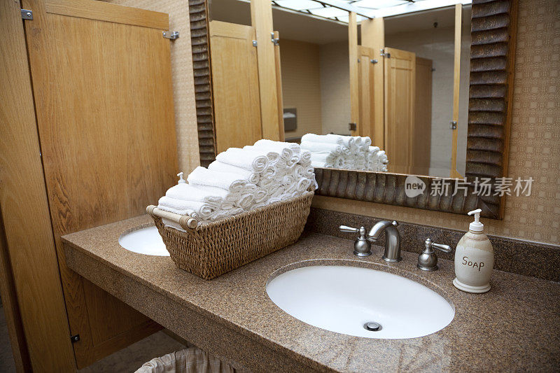 酒店公共厕所水槽;镜子，毛巾，大理石柜台