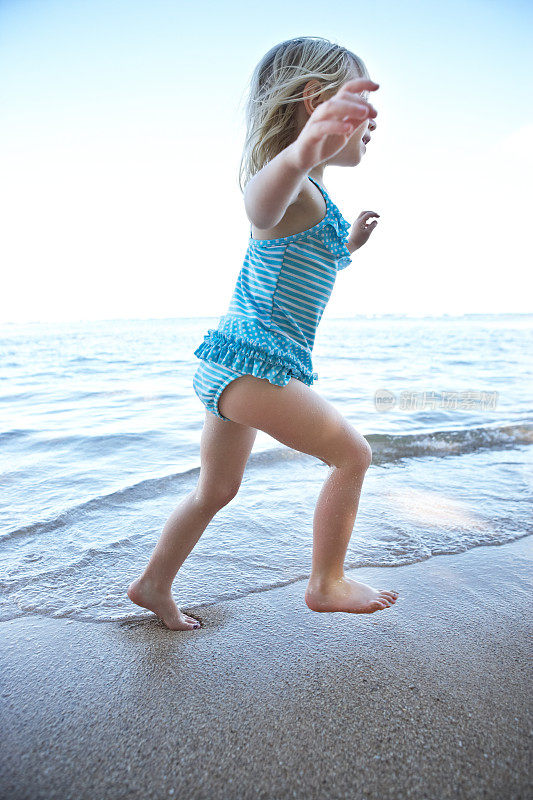美丽的小女孩在沙滩上奔跑