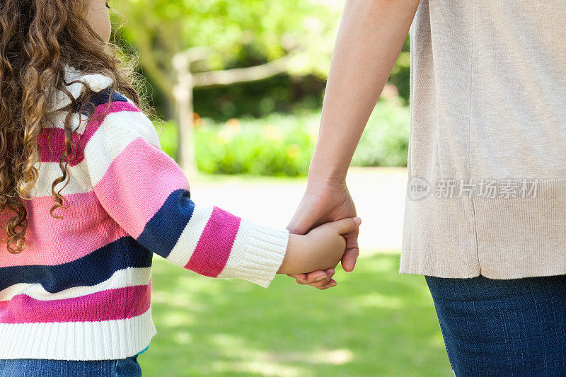 女孩牵着她妈妈的手