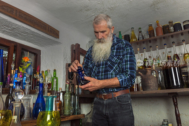 酒窖里的老男人，酒瓶，药草和水果