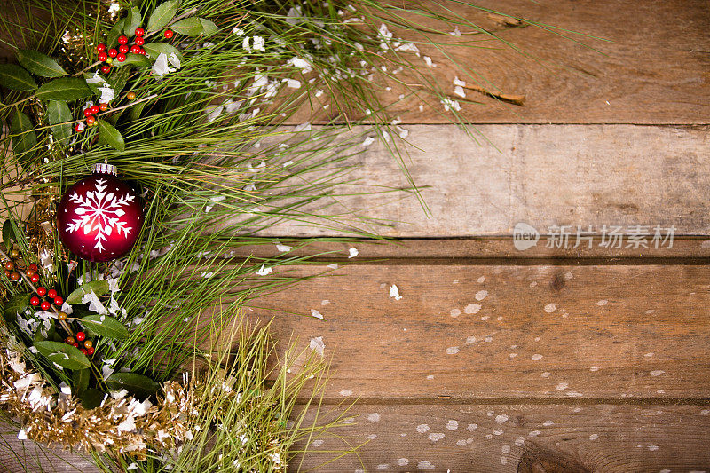 圣诞节的边界。点缀，松枝，冬青，雪。木制的桌子。