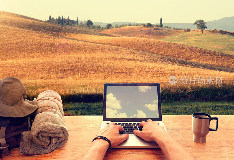 数字游牧民使用笔记本电脑在意大利的一个山坡小镇