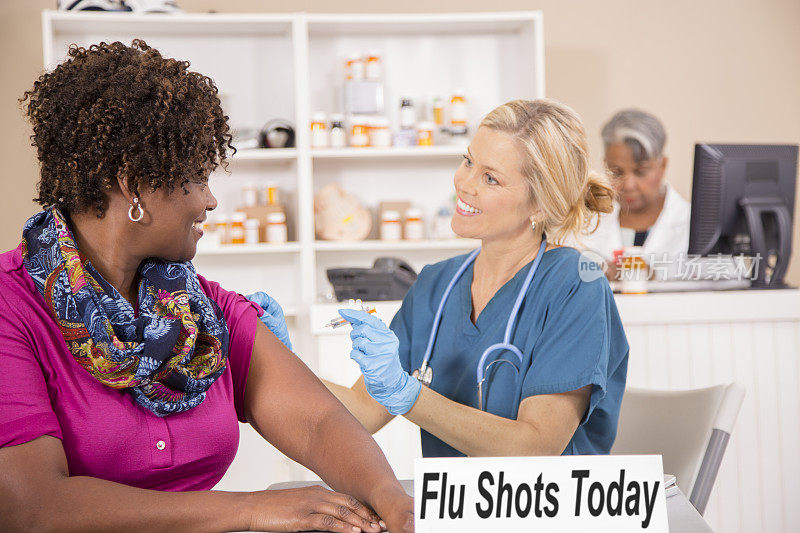 护士在药房给病人注射流感疫苗。