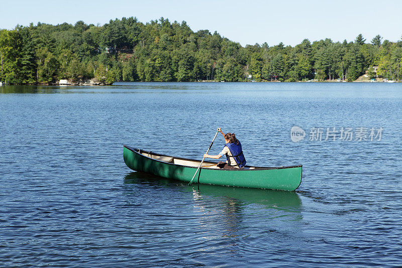 户外女孩在湖上划着独木舟