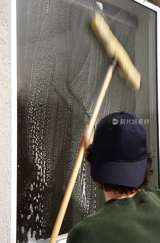 男人在清洗窗户(从后面)