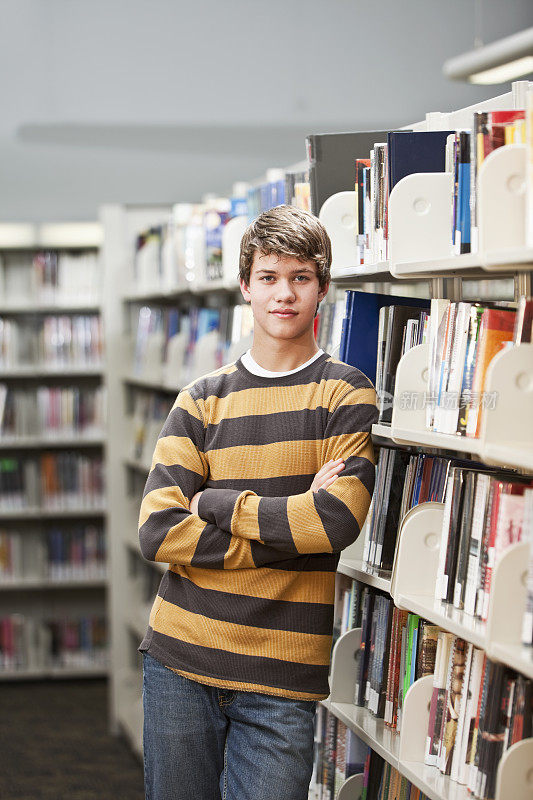 一个少年站在图书馆里