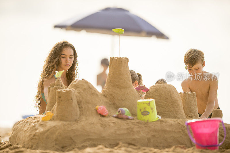 孩子们在夏威夷的海滩上建造沙堡