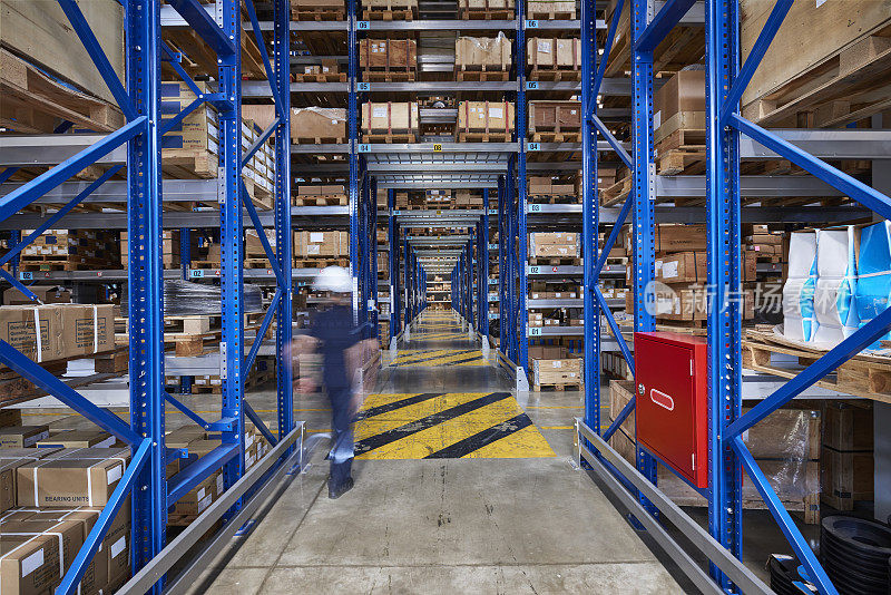 同事走在仓库过道上。
