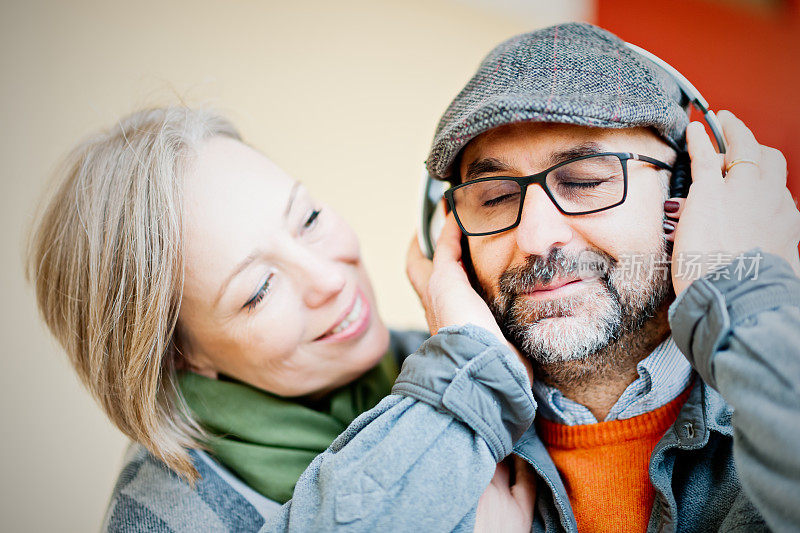 一对成熟的情侣通过耳机分享音乐