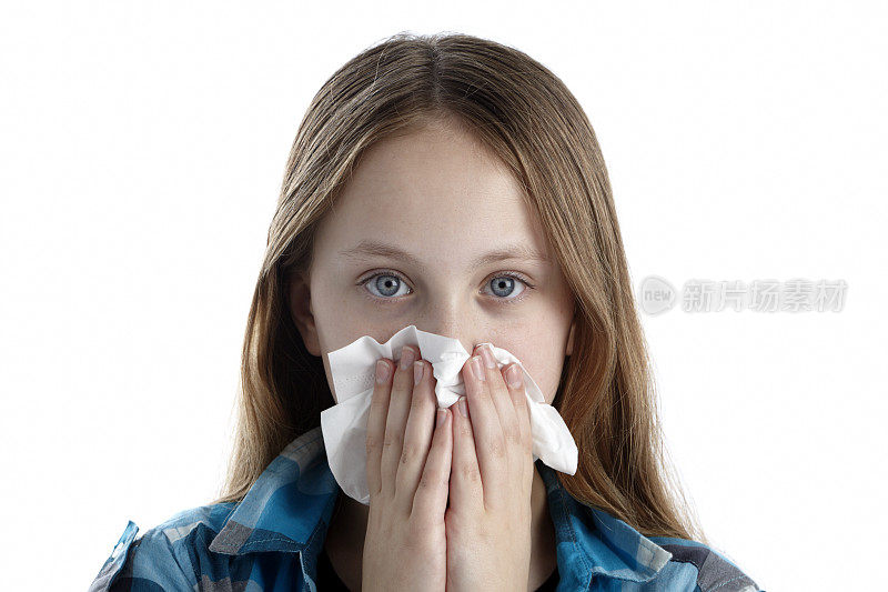 患有感冒或流感的金发女孩用纸巾擤鼻子