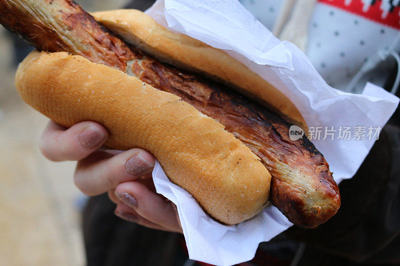 德国街头小吃的形象，手拿着小面包夹着的德国香肠