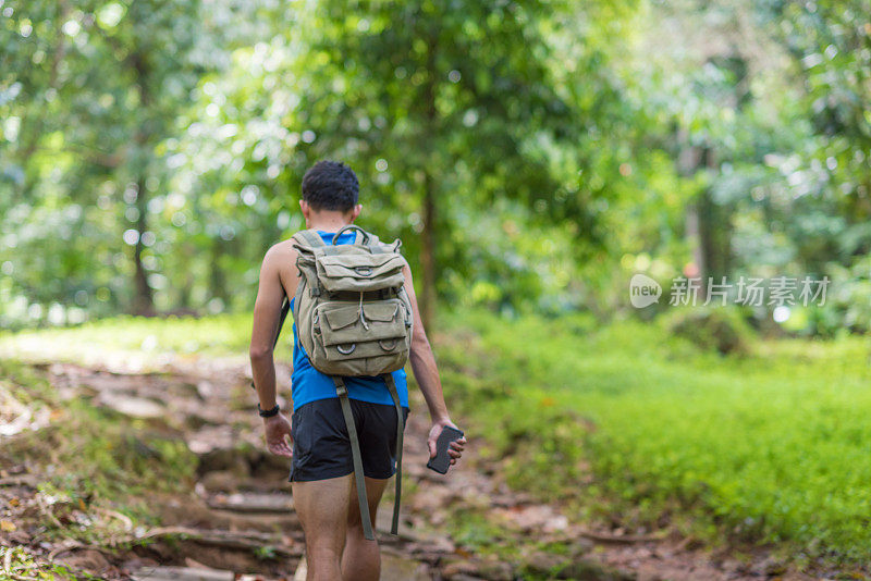 年轻的亚洲男子在热带森林夏季跑步健身