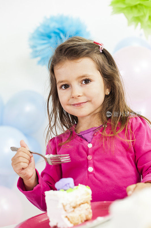 小女孩在生日聚会上吃蛋糕