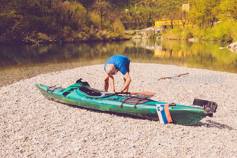 年长男子与白头发，胡子和小胡子准备皮划艇，索卡河，斯洛文尼亚
