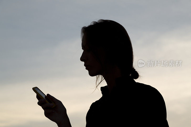 剪影女人手机掌上电脑短信天空