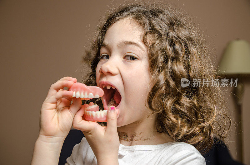 小女孩在玩外婆的假牙