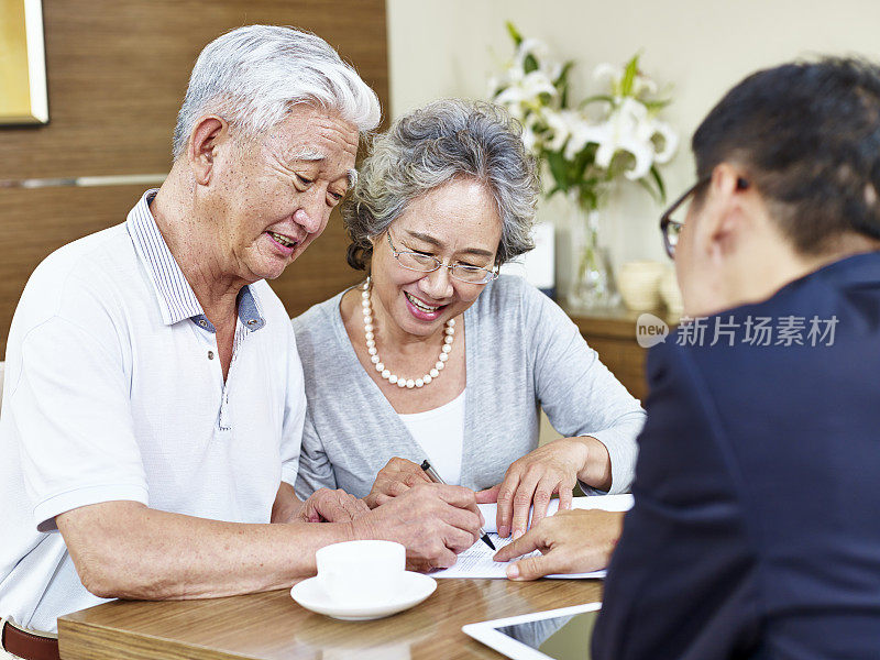 年老的亚洲夫妇签署一份合同