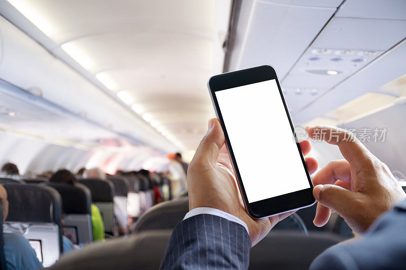 飞机乘客在飞机上使用智能手机。