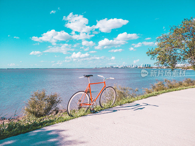 固定齿轮自行车没有刹车在海滨边缘凉爽的日落，复古复古风格的铬部件