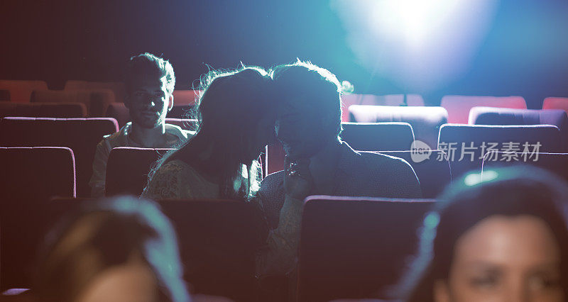 一对恩爱的情侣在电影院接吻