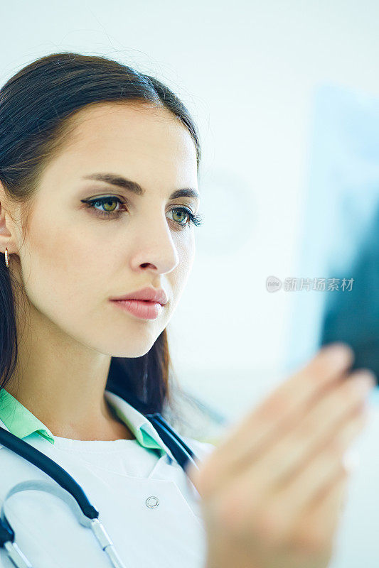一个年轻的女医生在看x光的特写肖像。