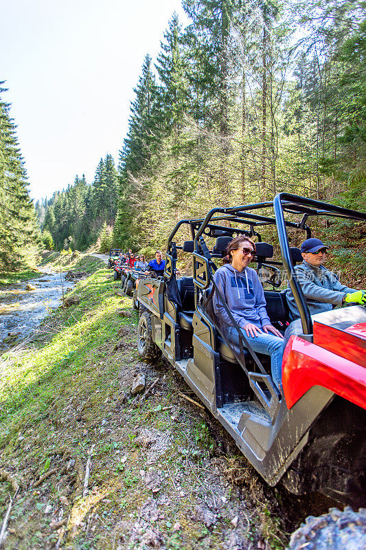 一个旅游团乘坐全地形车和utv在山上旅行