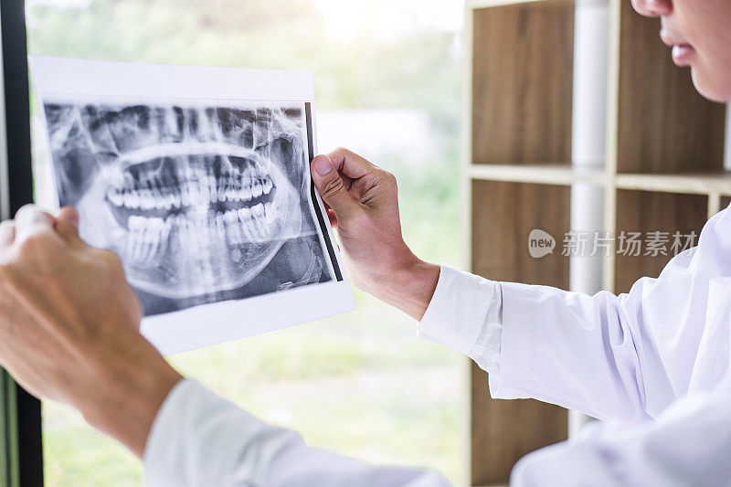 男医生或牙医拿着看牙科x光片