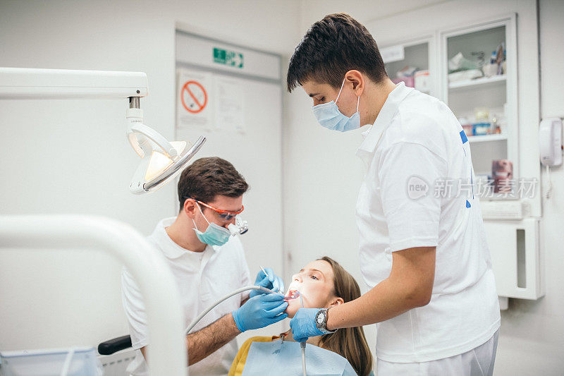 牙科医生和助手在病人身上工作