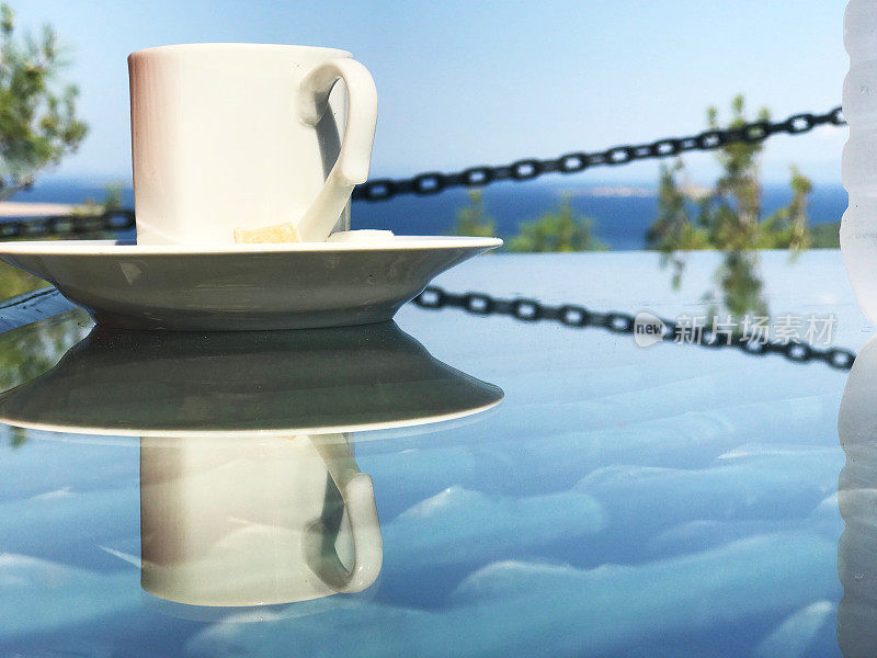 热咖啡在桌子上，可以看到大海
