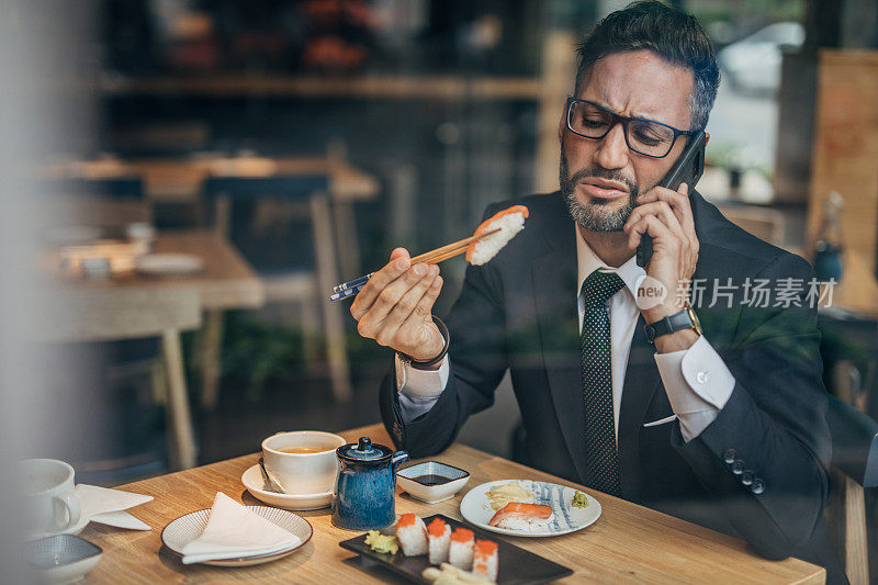 在寿司店打电话的男人