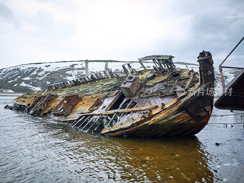 俄罗斯科拉半岛捷里别尔卡巴伦支海岸边的一艘废弃的老木船