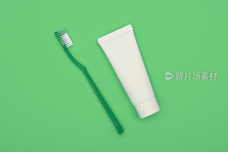 上图为绿色背景上的牙膏和牙刷