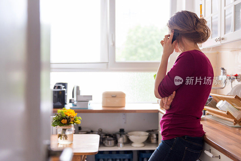 一个年轻女子在家里打电话