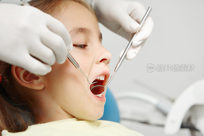 近距离拍摄的牙医检查微笑的孩子在儿科牙科诊所。