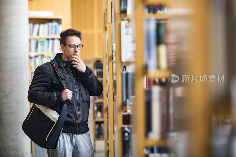 青年学生站在图书馆里思考
