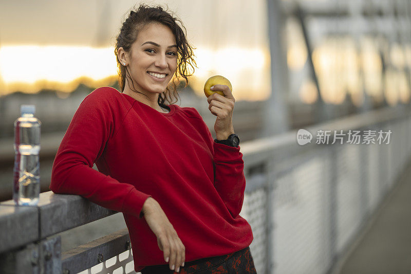 快乐运动女性在户外运动训练后吃健康零食的肖像