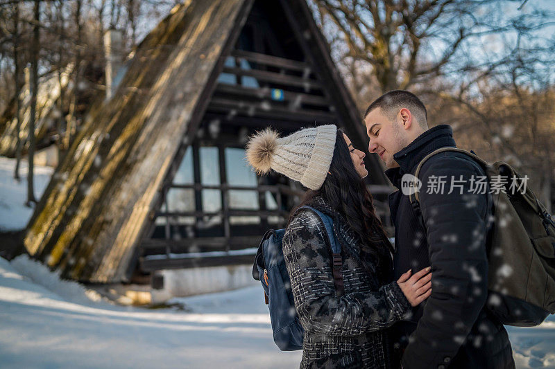 这对快乐的情侣在雪山徒步旅行时微笑着用手机自拍