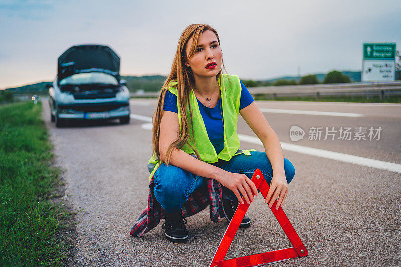 女人把三角形警告标志放在路上