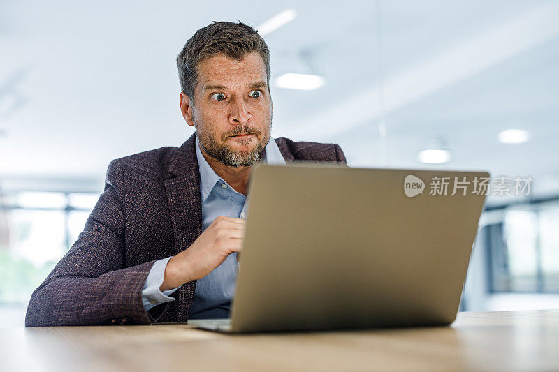 中年男性企业家在办公室通过笔记本电脑进行视频通话时感到沮丧。