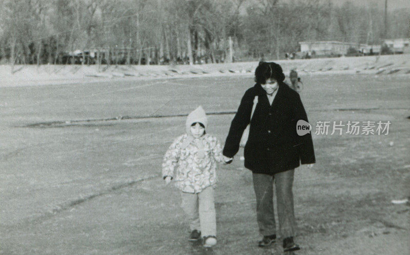 80年代中国年轻妈妈和女儿在冰上玩黑白老照片