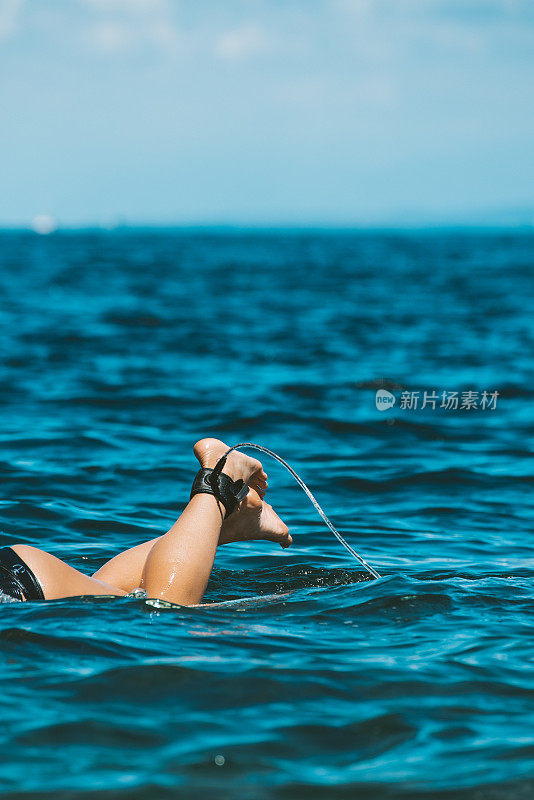 女孩在冲浪板上划桨