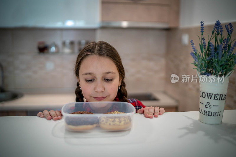 快乐的女孩吃着美味的甜甜圈