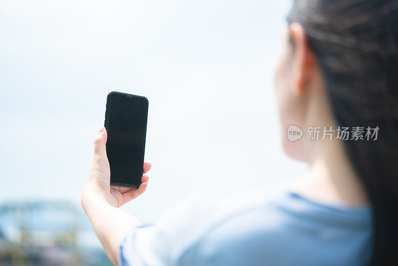 亚洲年轻女性在户外使用智能手机