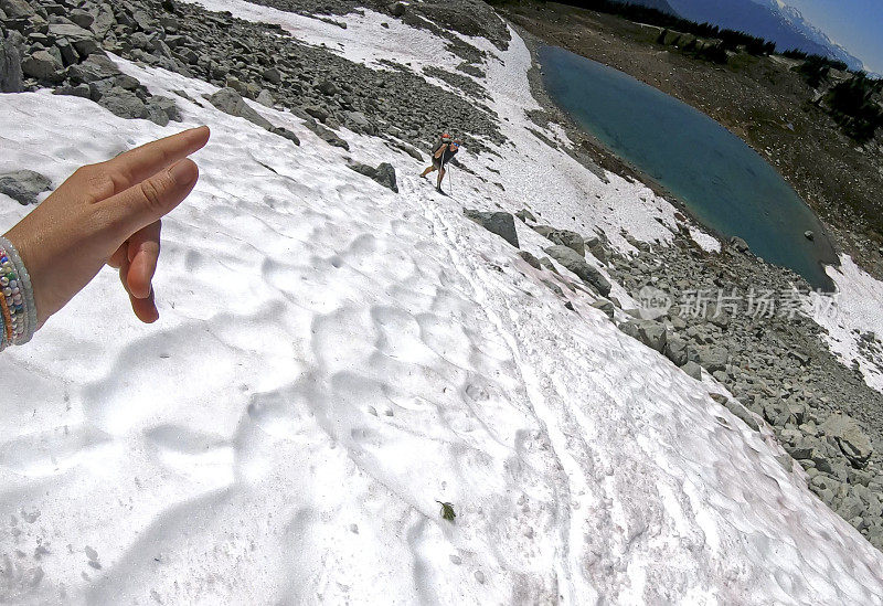 徒步旅行者沿着积雪的山坡跑下去