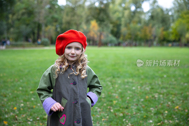 一个戴着红色贝雷帽的小女孩的肖像。