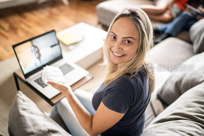 一个成熟女人在家里清理笔记本电脑的肖像